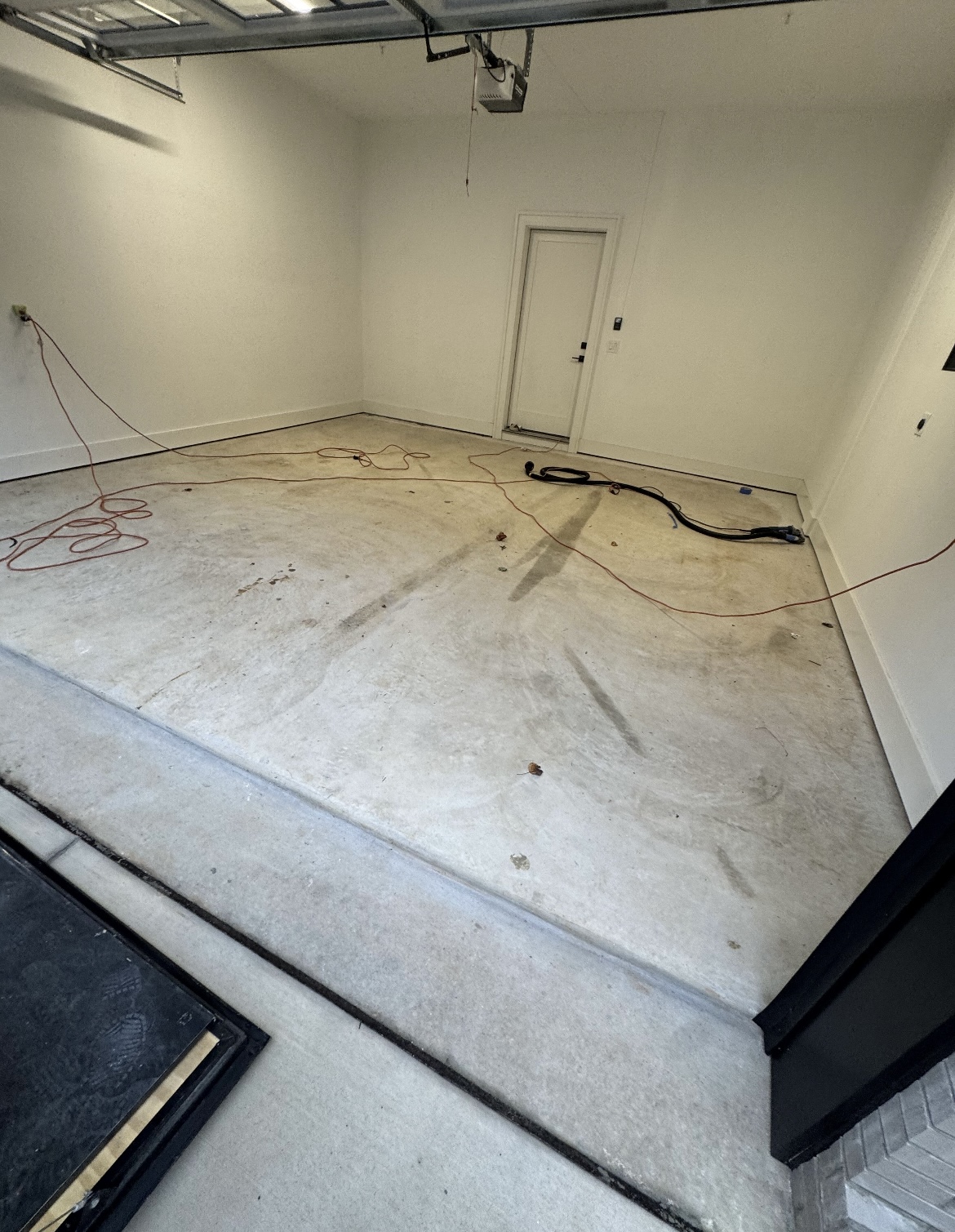 Bare, stained concrete garage floor before coating